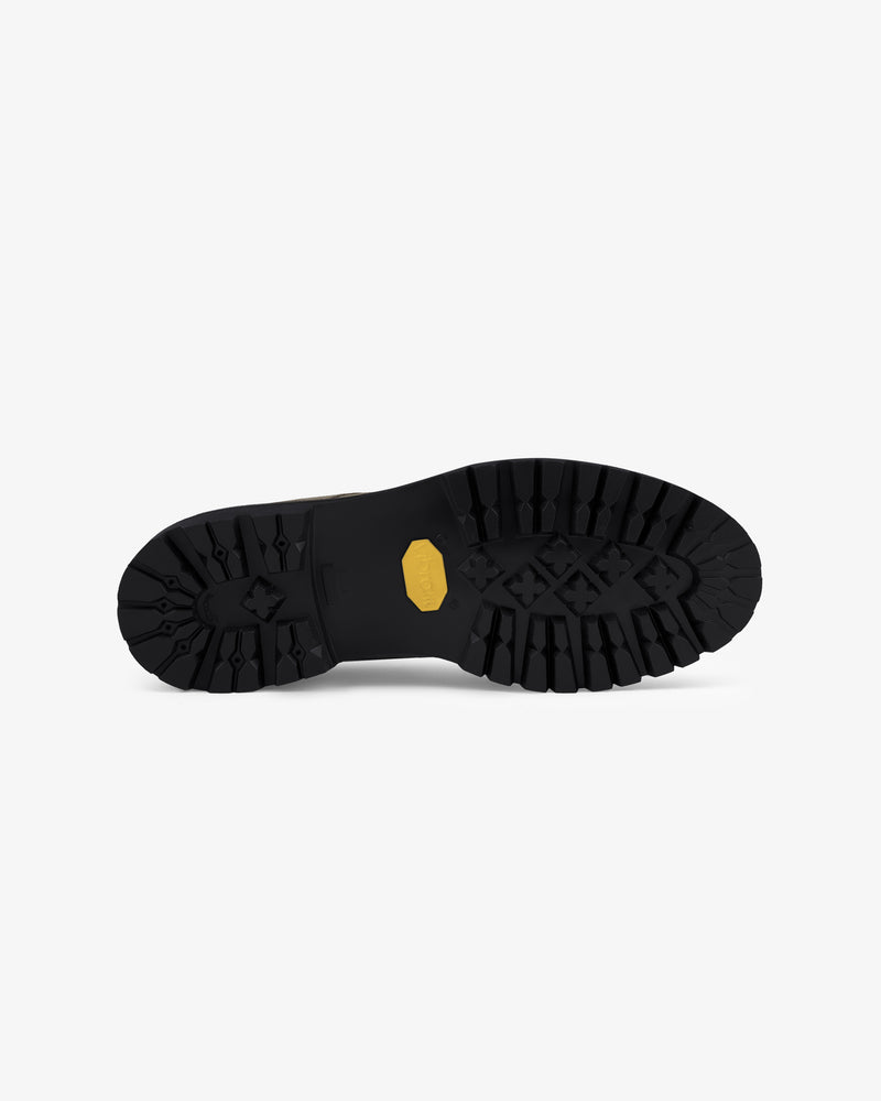 Suede Lug Sole Derby featuring a rugged black sole with a yellow hexagonal logo, shown on a white background.