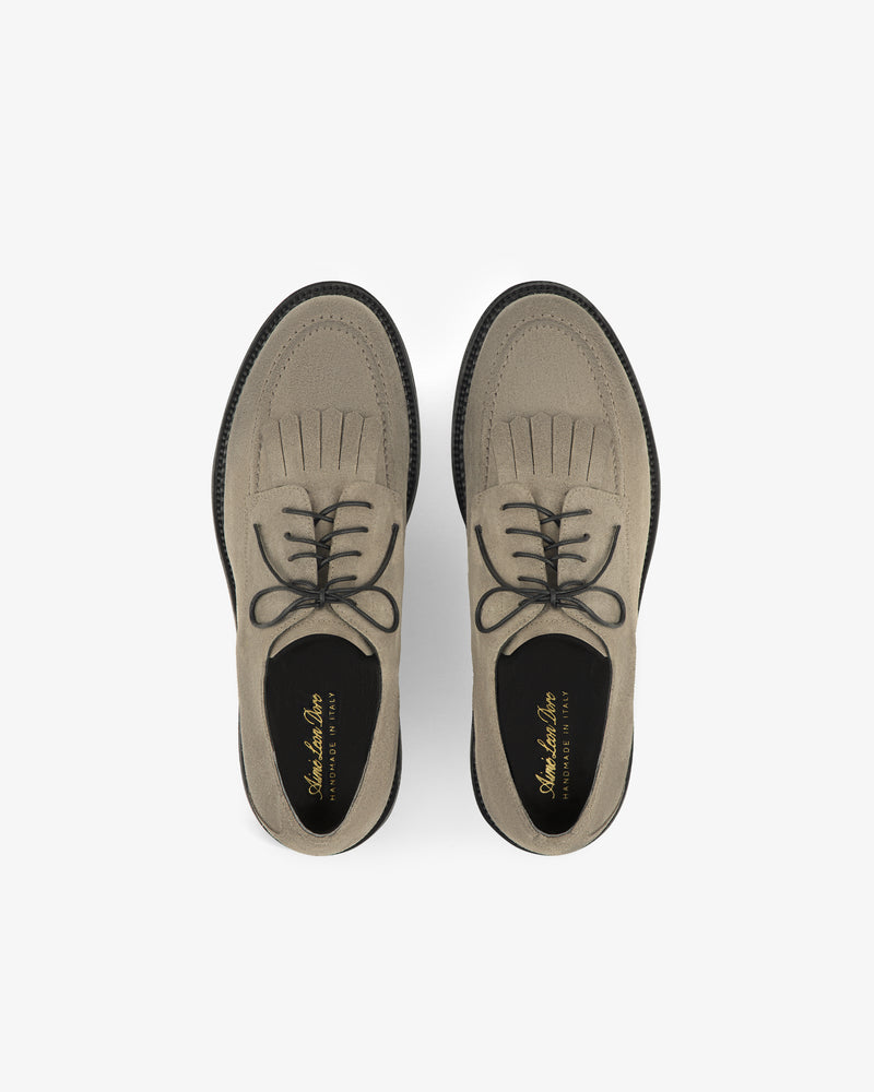 Beige Suede Lug Sole Derby shoes with black soles, top view on a white background.