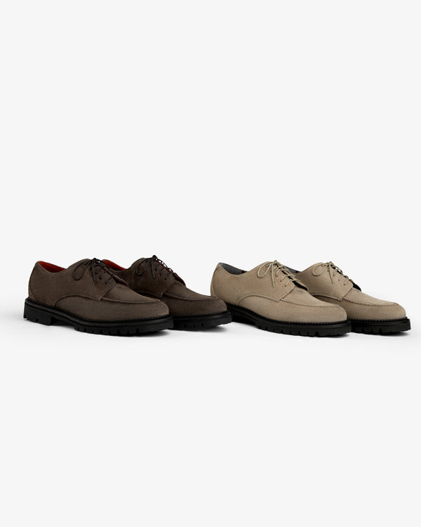 A dark brown and a beige Suede Lug Sole Derby, both featuring thick black lug soles.