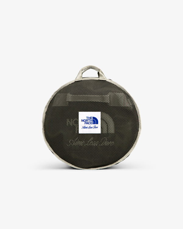Small round mesh duffel with gray trim, handle, and white “The North Face” label—ALD / The North Face Base Camp Duffel.