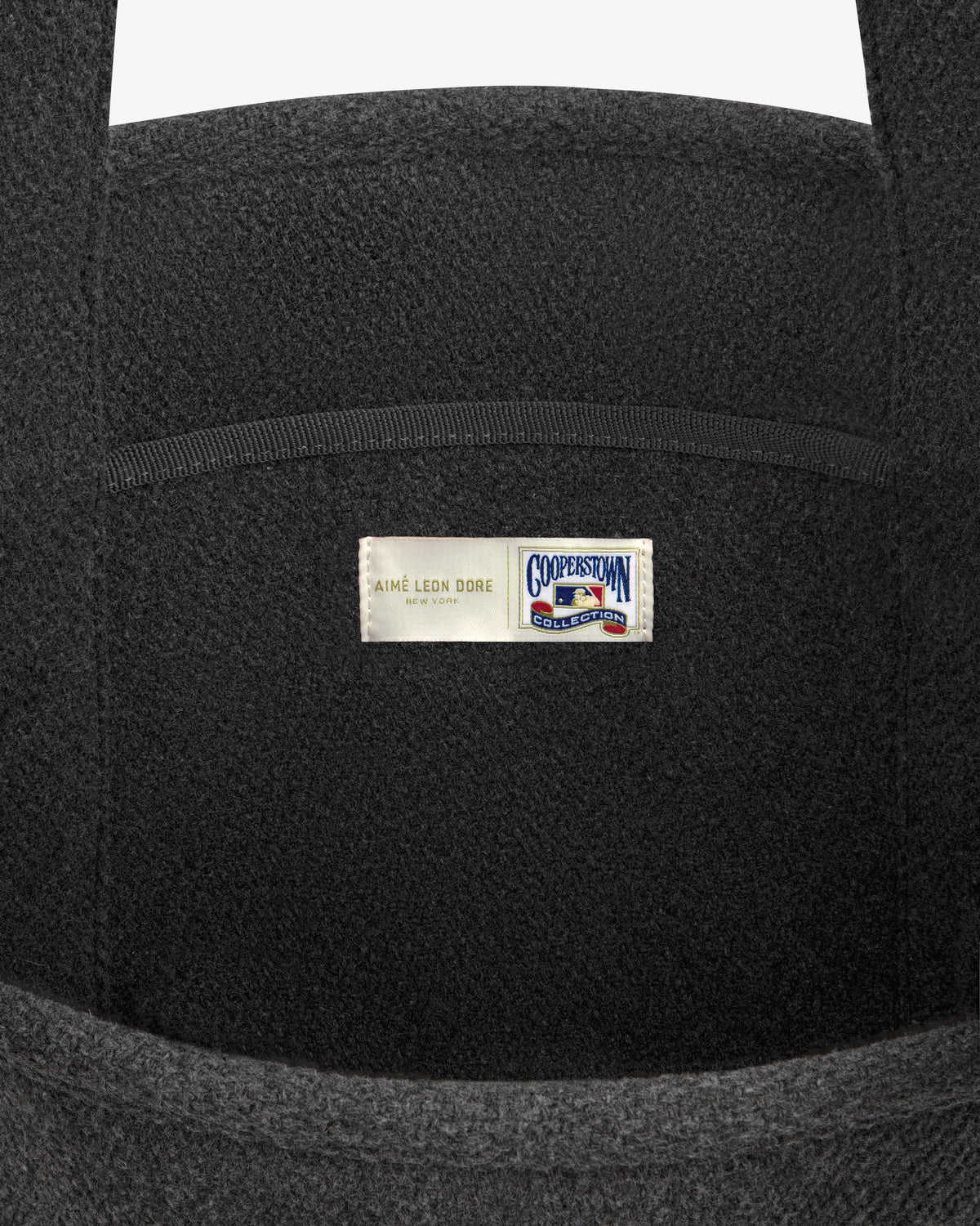 NY Highlanders Wool Tote Bag in dark grey, featuring a label with Aimé Leon Dore and Cooperstown Collection logos.