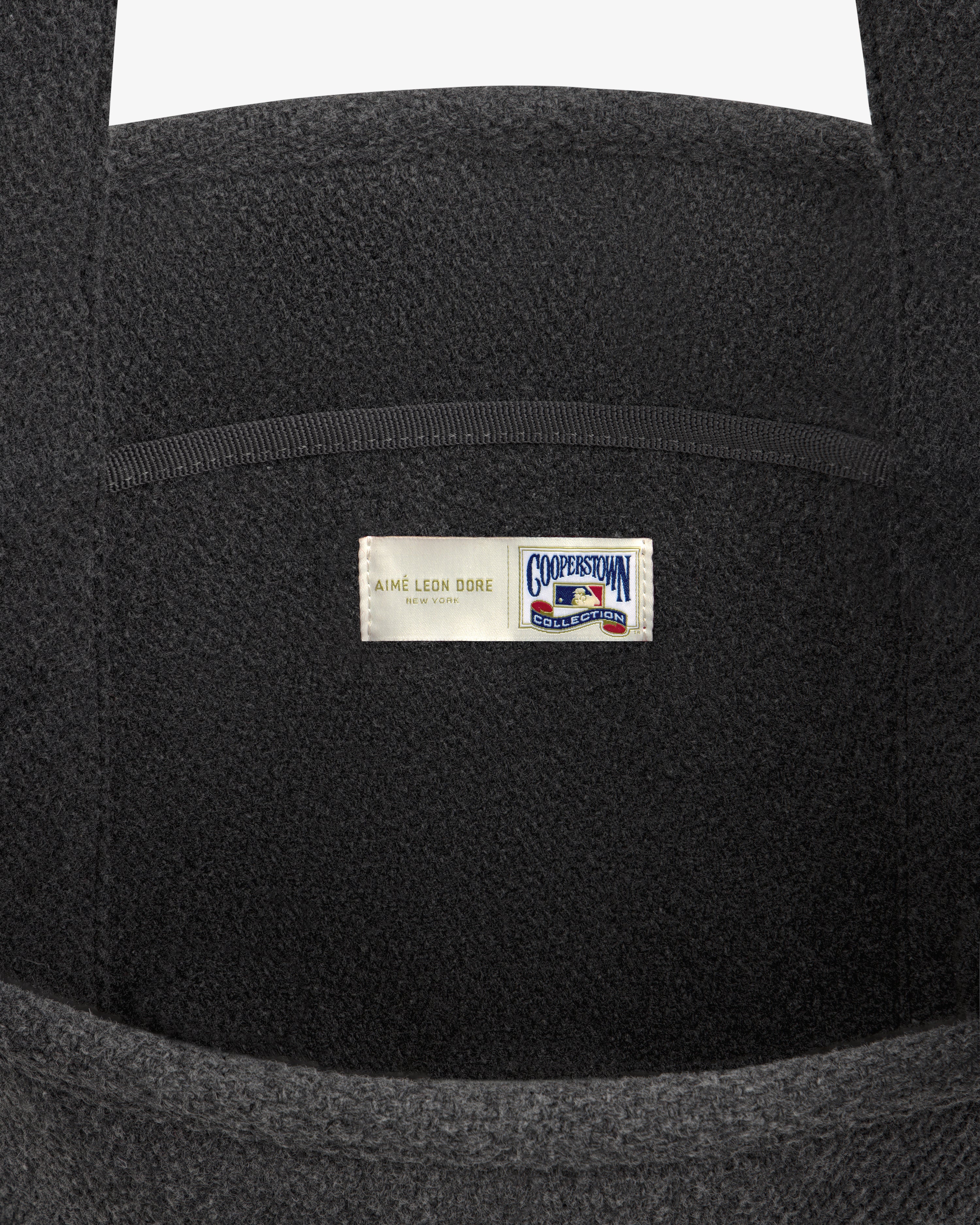 NY Highlanders Wool Tote Bag in dark grey, featuring a label with Aimé Leon Dore and Cooperstown Collection logos.