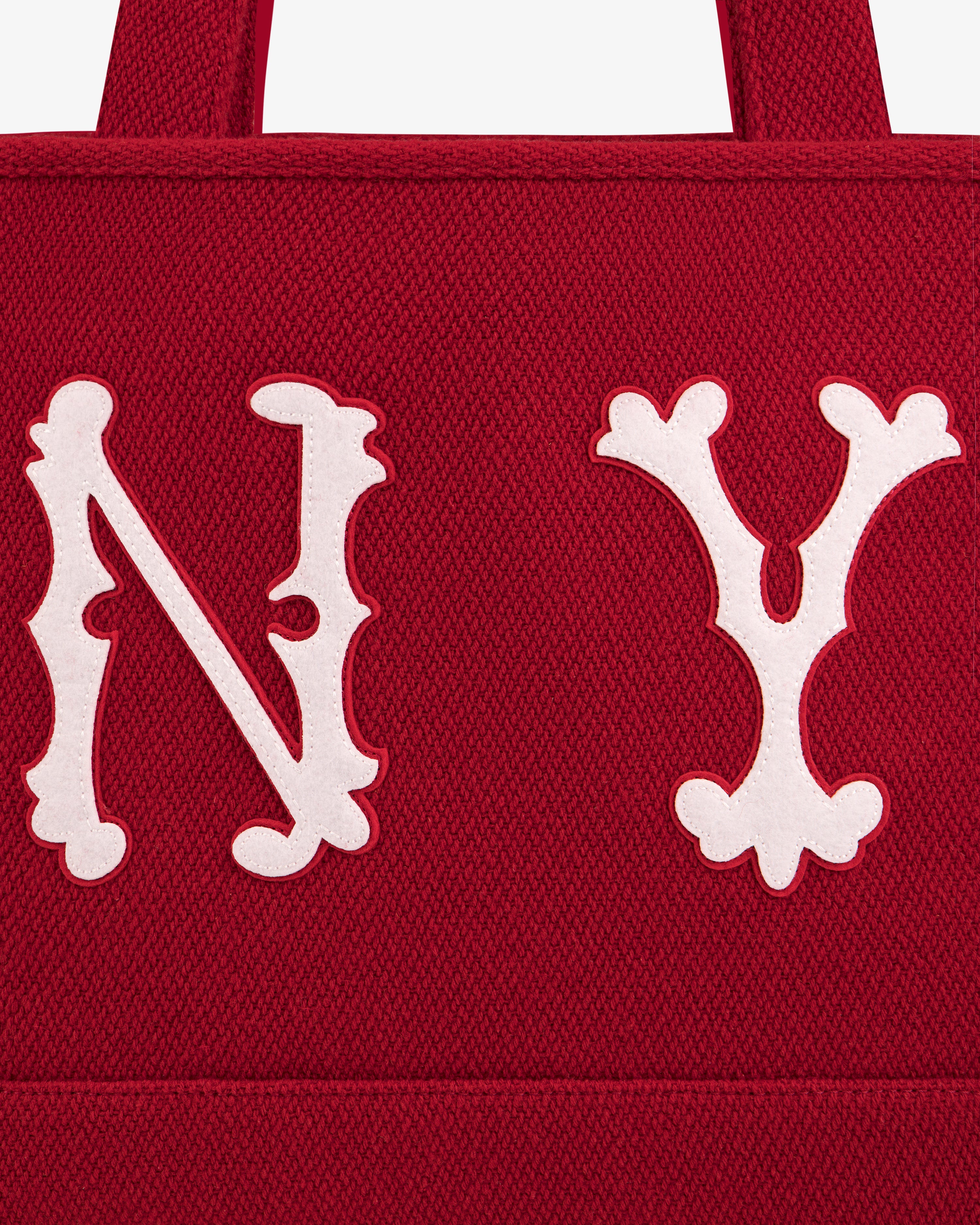 A red, textured NY Highlanders Wool Tote Bag with large, white, decorative N Y lettering appliquéd on the front.