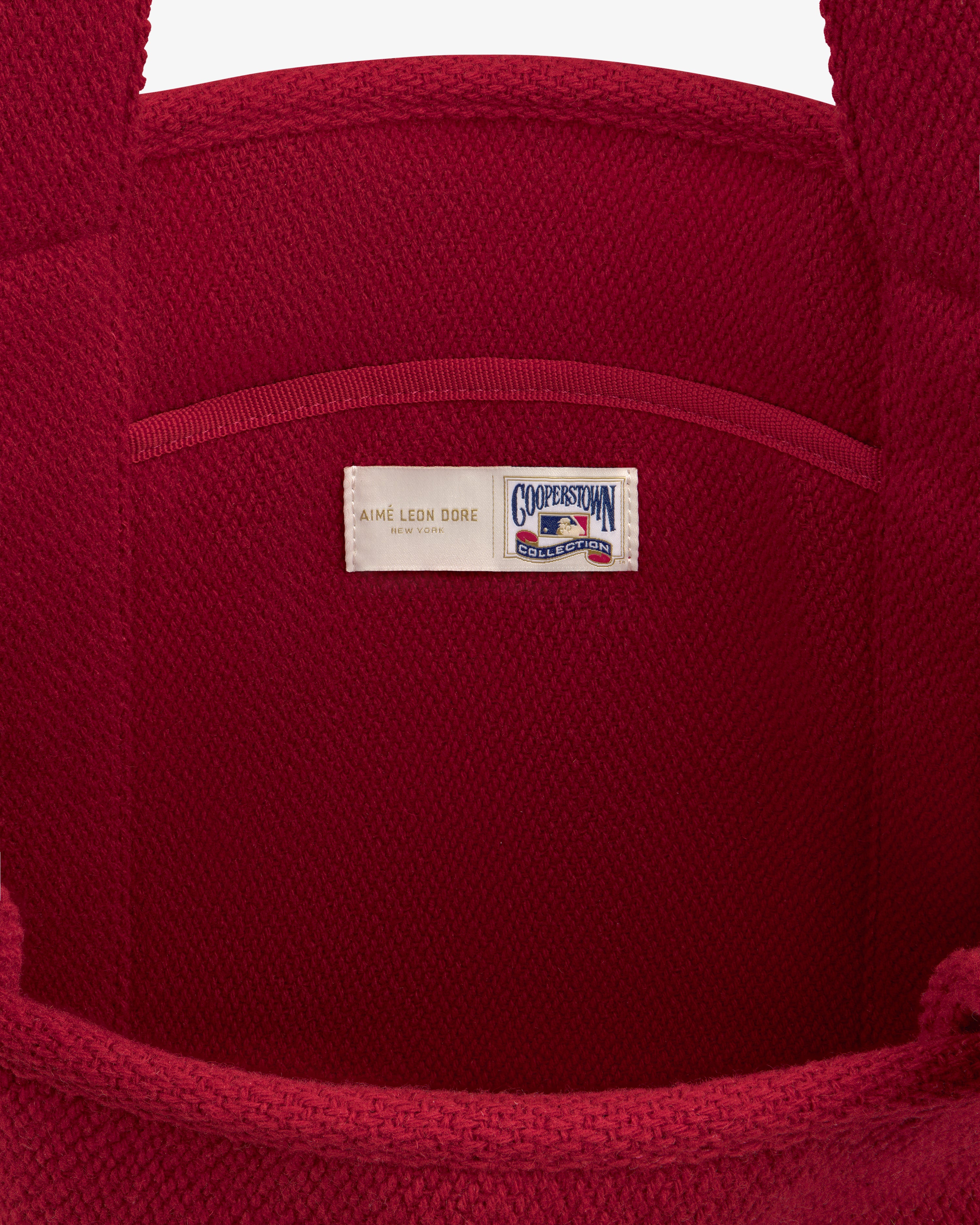 Interior of a red wool NY Highlanders Wool Tote Bag featuring a Cooperstown Collection brand label.
