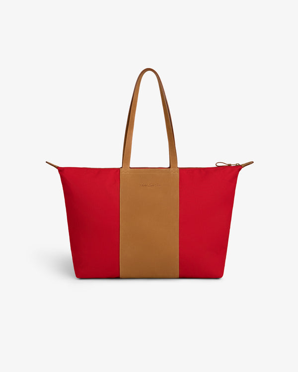 Leather Canvas Zip Tote in red with tan handles and a central tan stripe, shown on a plain white background.