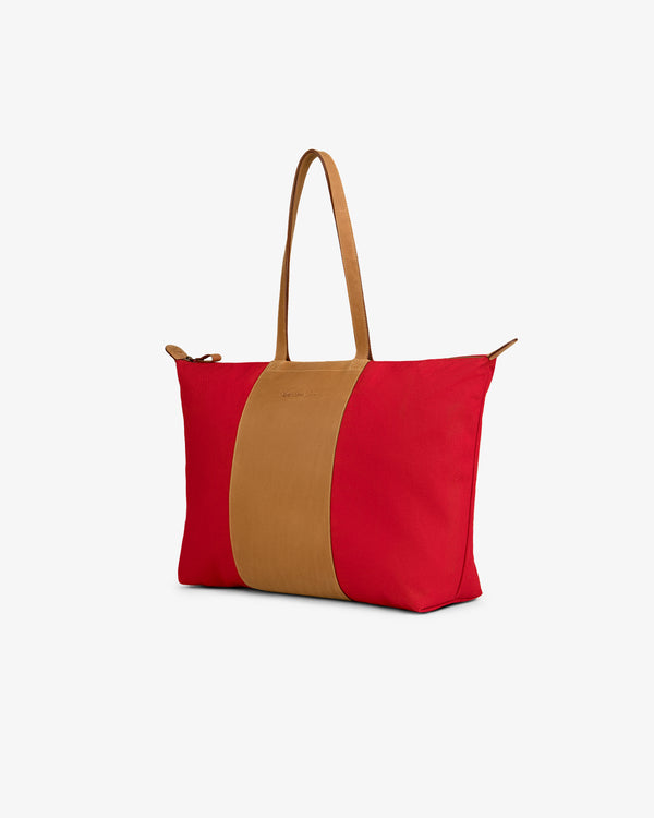 Leather Canvas Zip Tote with red canvas sides, wide tan leather center strip, and matching tan handles.