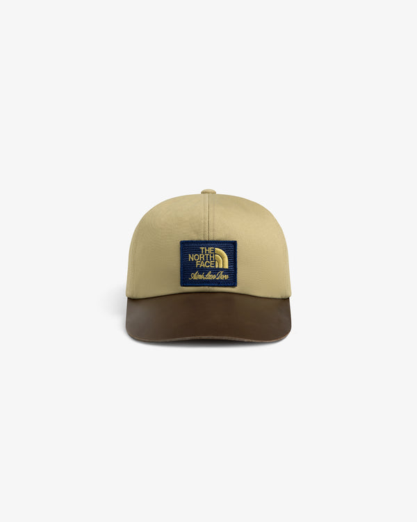 Beige and brown ALD / The North Face Leather Brim Logo Hat with blue patch, shown on a white background.