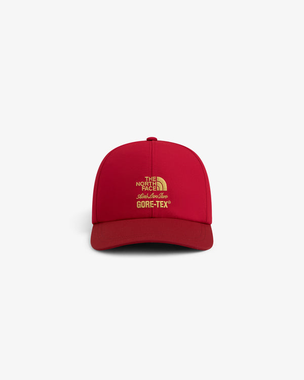 Front view of red ALD / The North Face GORE-TEX Hat with yellow logo on white background.