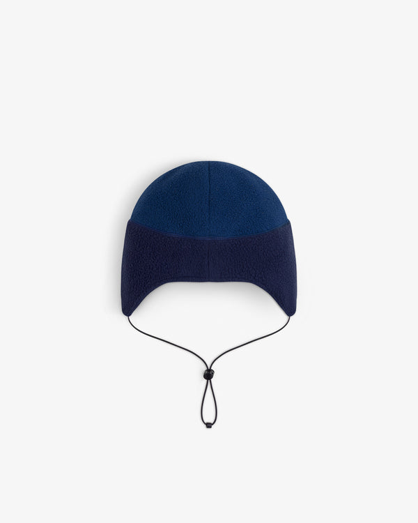 ALD/The North Face Fleece Earflap Hat in two-tone blue with ear flaps, black chin strap, on white background.