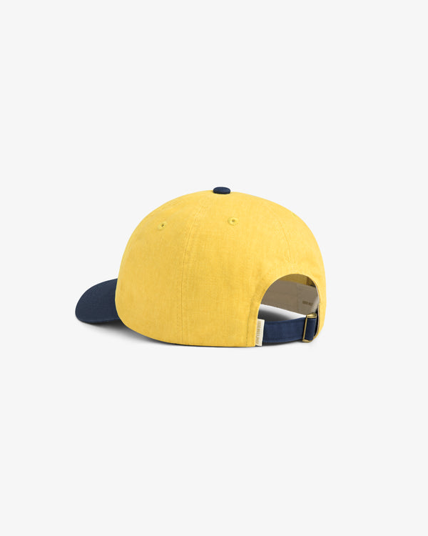 Pigment Dyed Logo Hat in yellow with navy strap and brim, back view on white background.