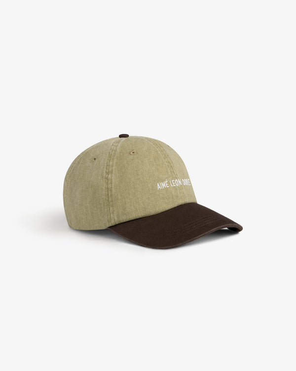 Pigment Dyed Logo Hat: green with a brown brim and white AIME LEON DORE text on front, shown on white background.