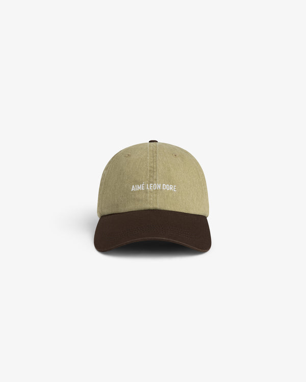 Pigment Dyed Logo Hat: Tan cap with dark brown brim and AIMÉ LEON DORE embroidered text on the front.