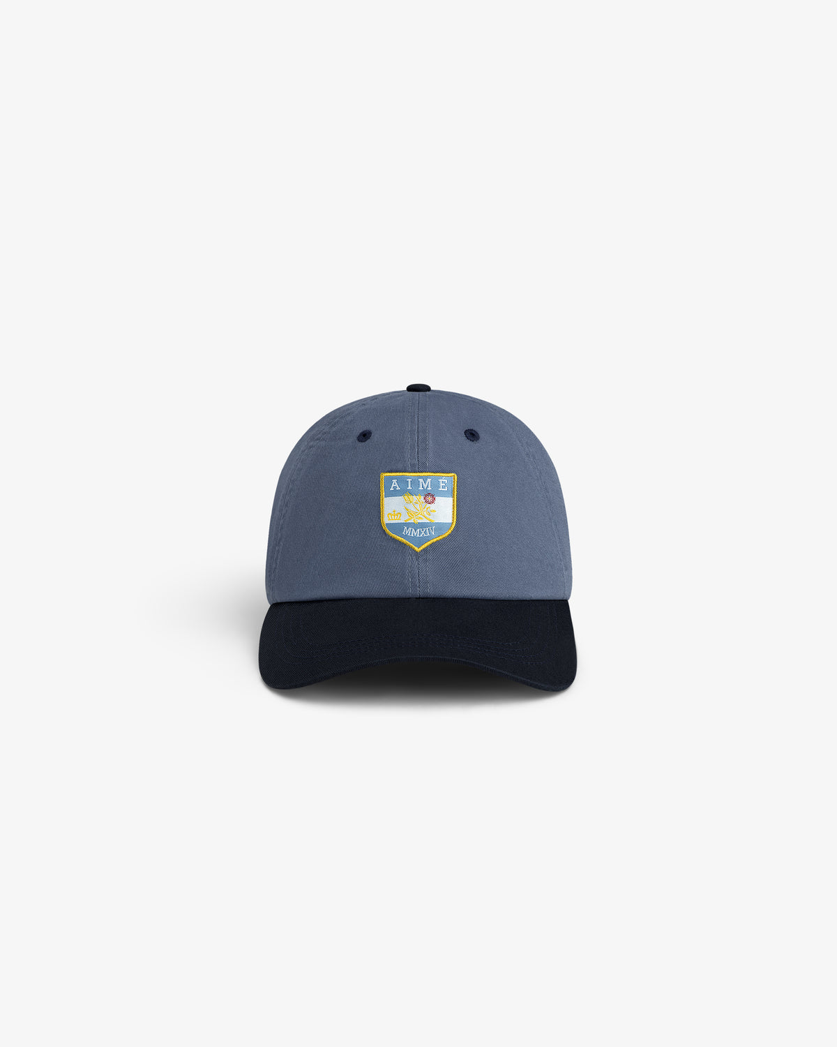 Crest Shield Hat: Blue cap with black brim, yellow-blue AIME LEON DORE HARVEST shield logo on the front.