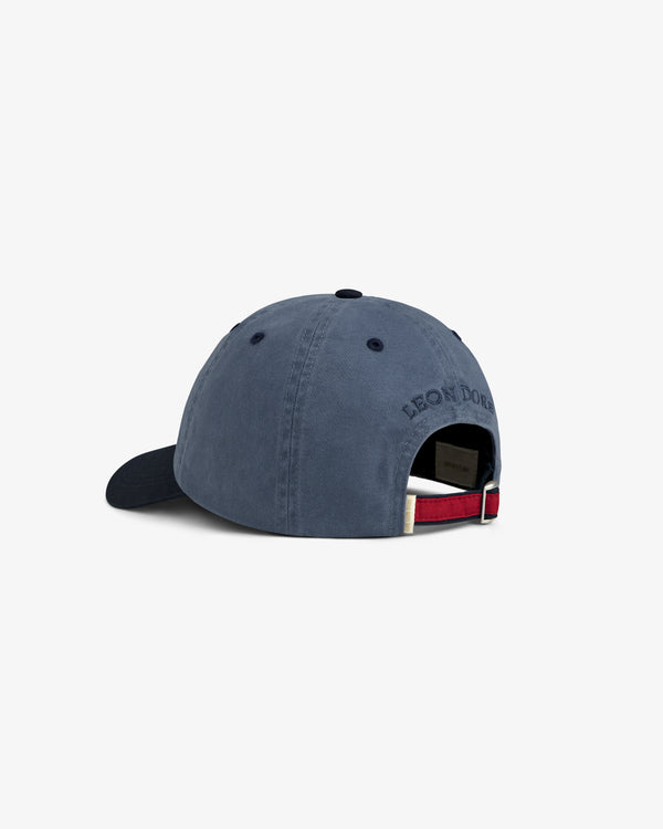 Crest Shield Hat in navy, shown from the back with metal buckle and red, white, and navy strap.
