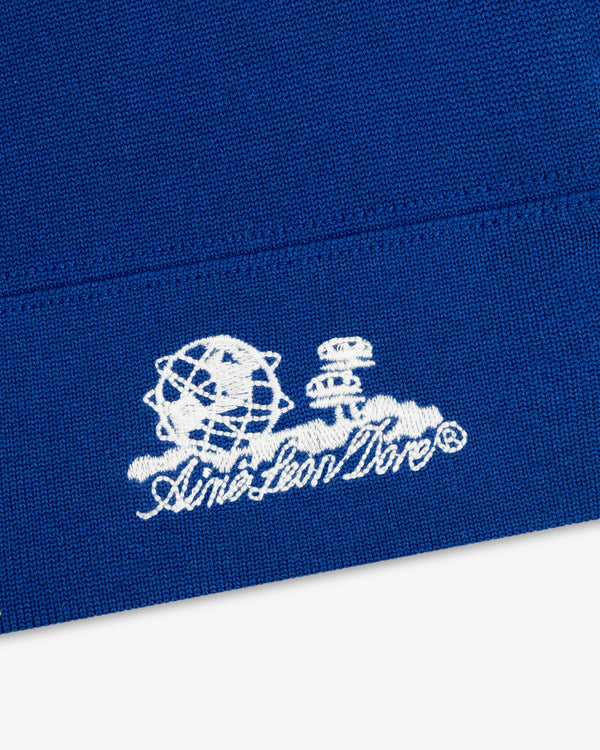 White “Unisphere Skull Cap” logo with globe and chess pieces, featured on blue fabric.
