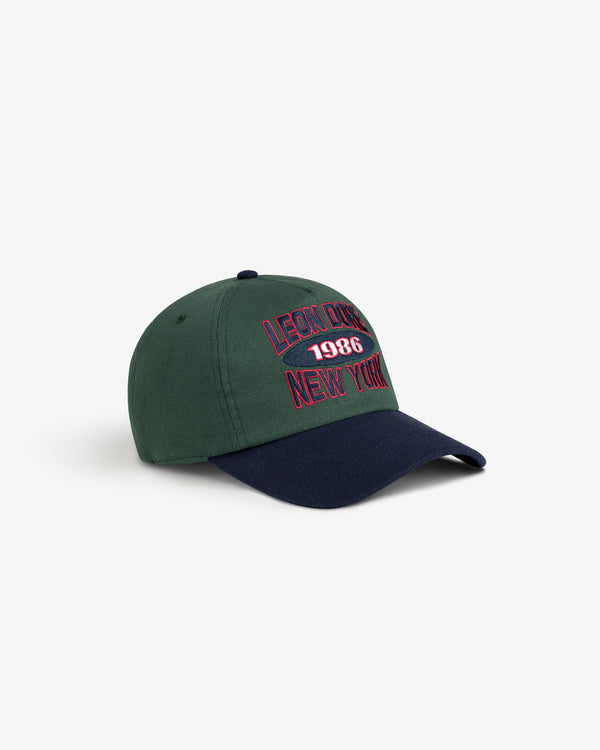 Colorblock Club Hat: green/navy cap with “Leon DNM 1986 New York” embroidered in red on the front.