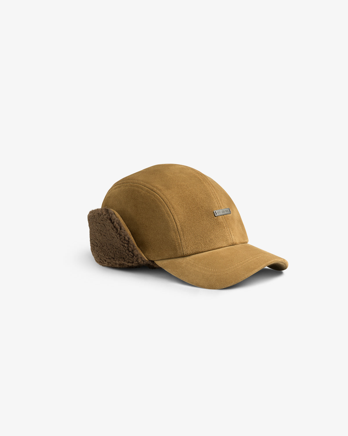 Tan Shearling Earflap Hat with fold-down fuzzy earflaps and a small rectangular logo plaque.