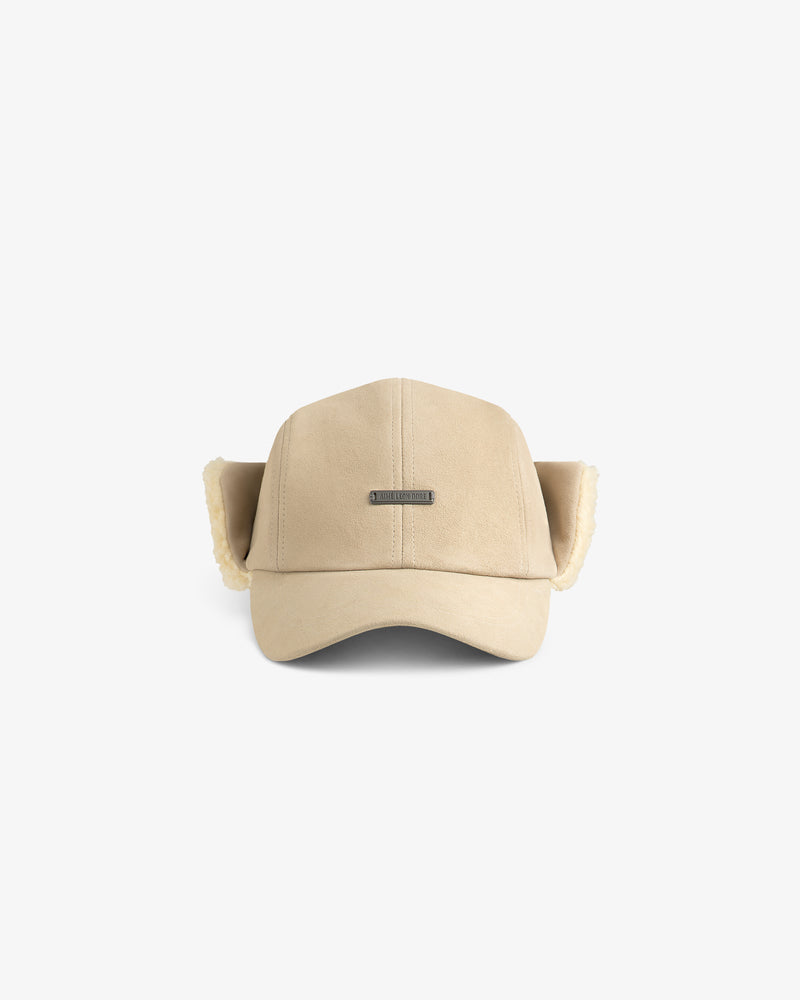 Shearling Earflap Hat in tan with fold-down earflaps lined with cream-colored fleece.