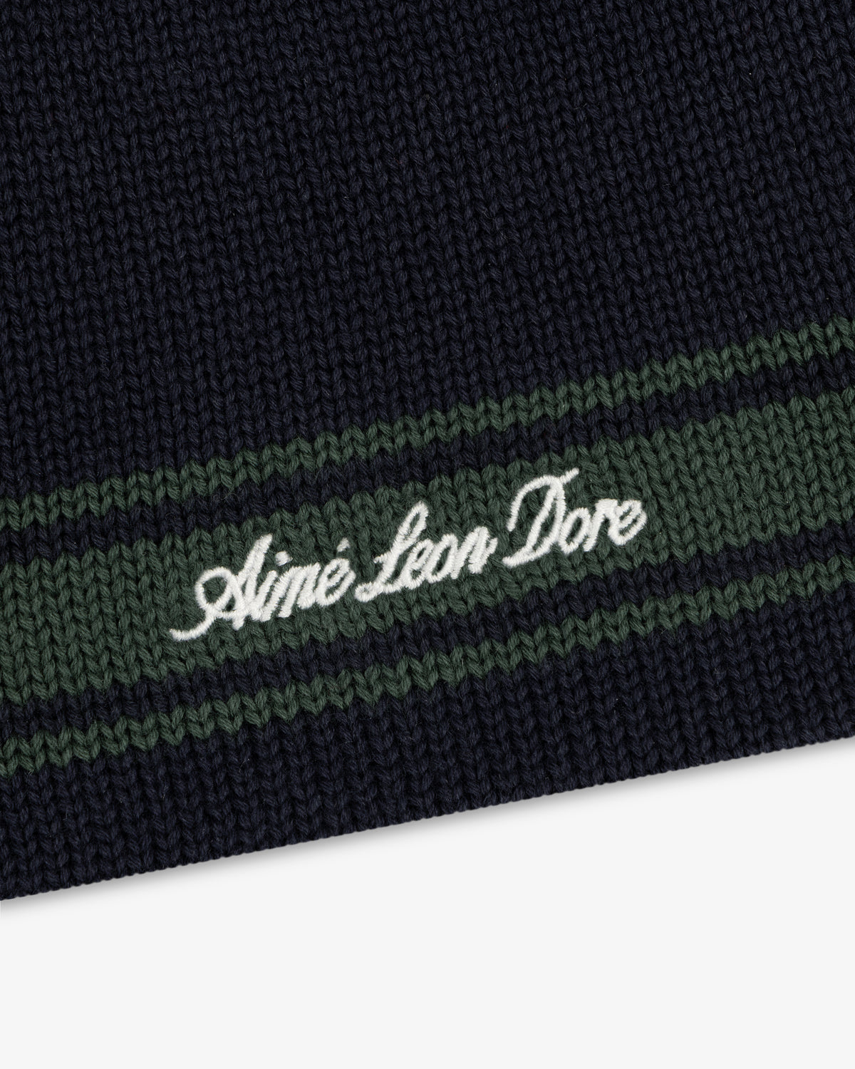 Navy Stripe Knit Beanie with green stripes and Aimé Leon Dore embroidered in white cursive.