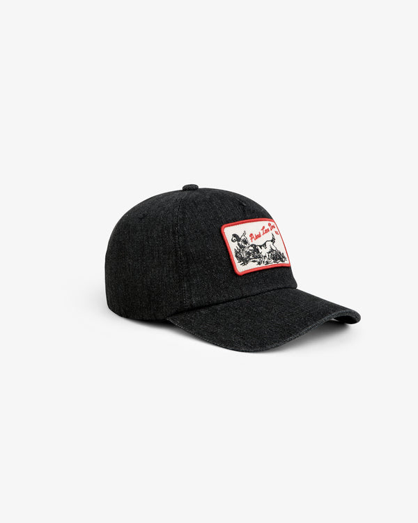 Aimé Retriever Hat: a black baseball cap with a rectangular patch featuring a dog illustration and red trim.