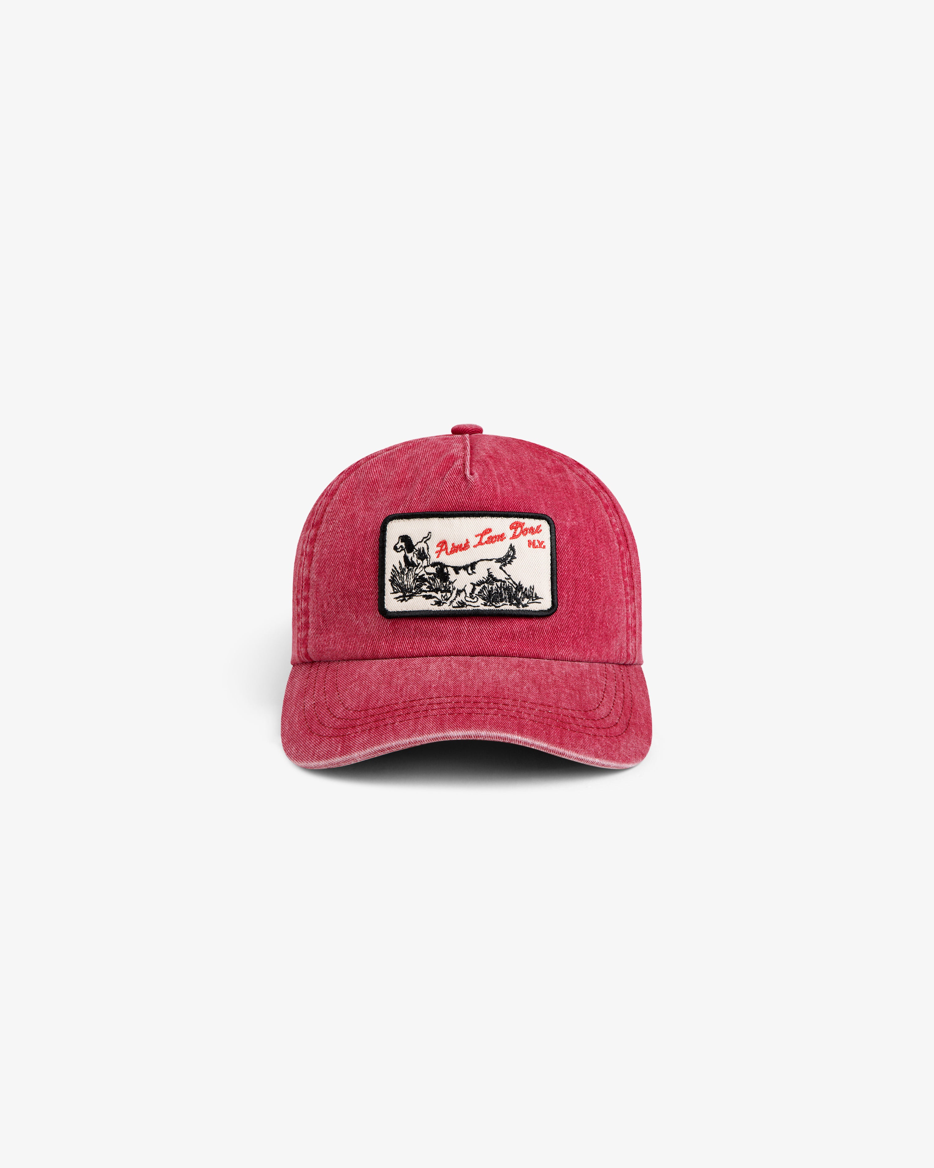 Faded red Aimé Retriever Hat with a rectangular patch featuring a graphic of a hunting dog in a field.