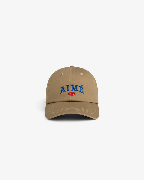 Aimé Souvenir Hat: Tan cap with blue AIMÉ text and a small red NYC logo, displayed on white background.