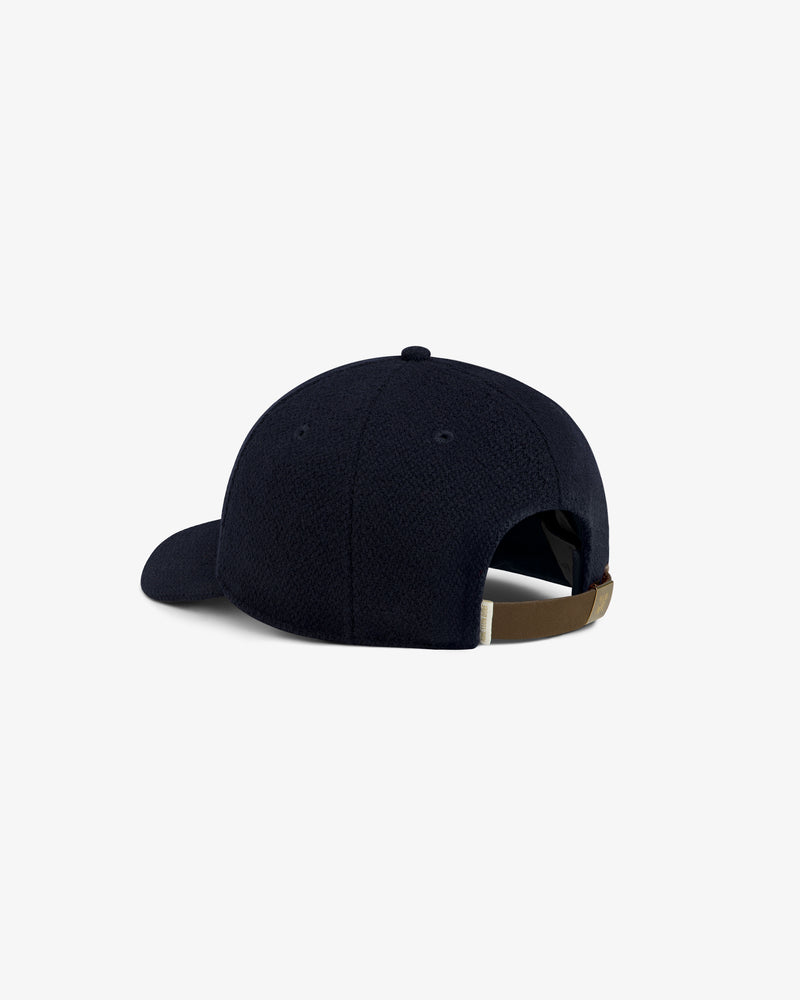 Wool Varsity Logo Hat in navy blue with an adjustable leather back strap.