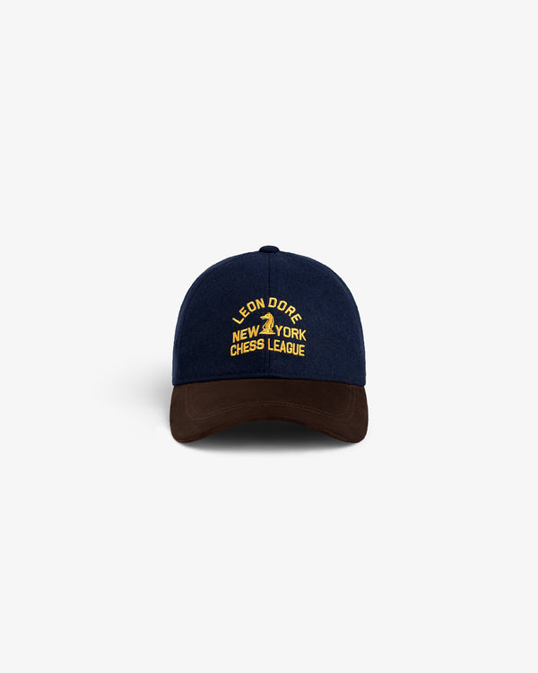 Navy Triborough Chess Club Wool Hat with yellow text and brown brim, displayed on a white background.