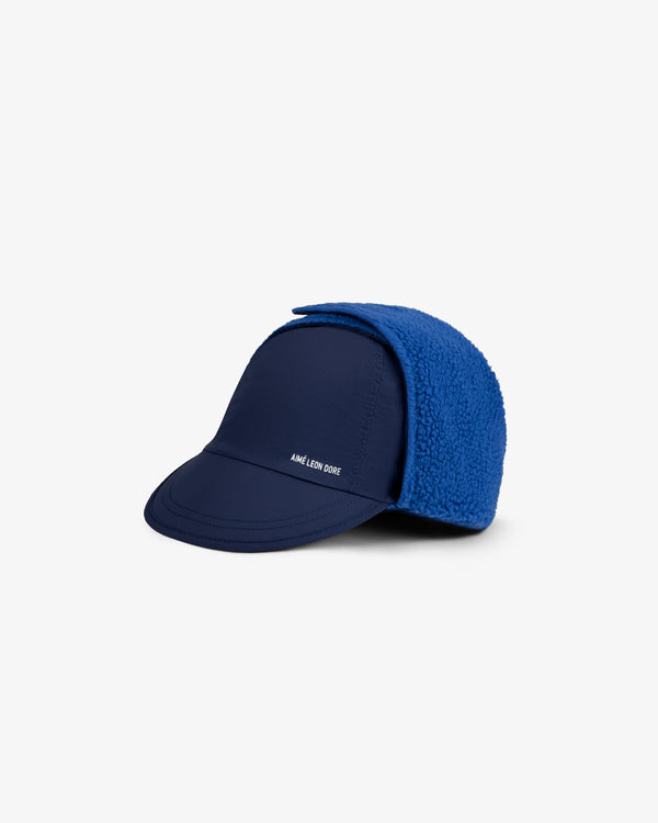 Fleece Lined Earflap Hat in navy blue with a curved brim and a bright blue textured earflap.