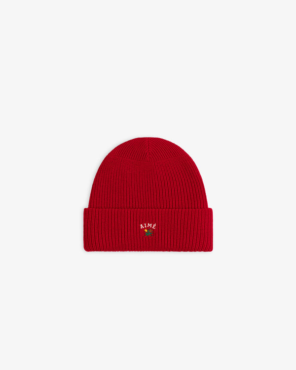 Crest Merino Wool Beanie: bright red, ribbed, folded brim, small AIME embroidery, green plant on front.