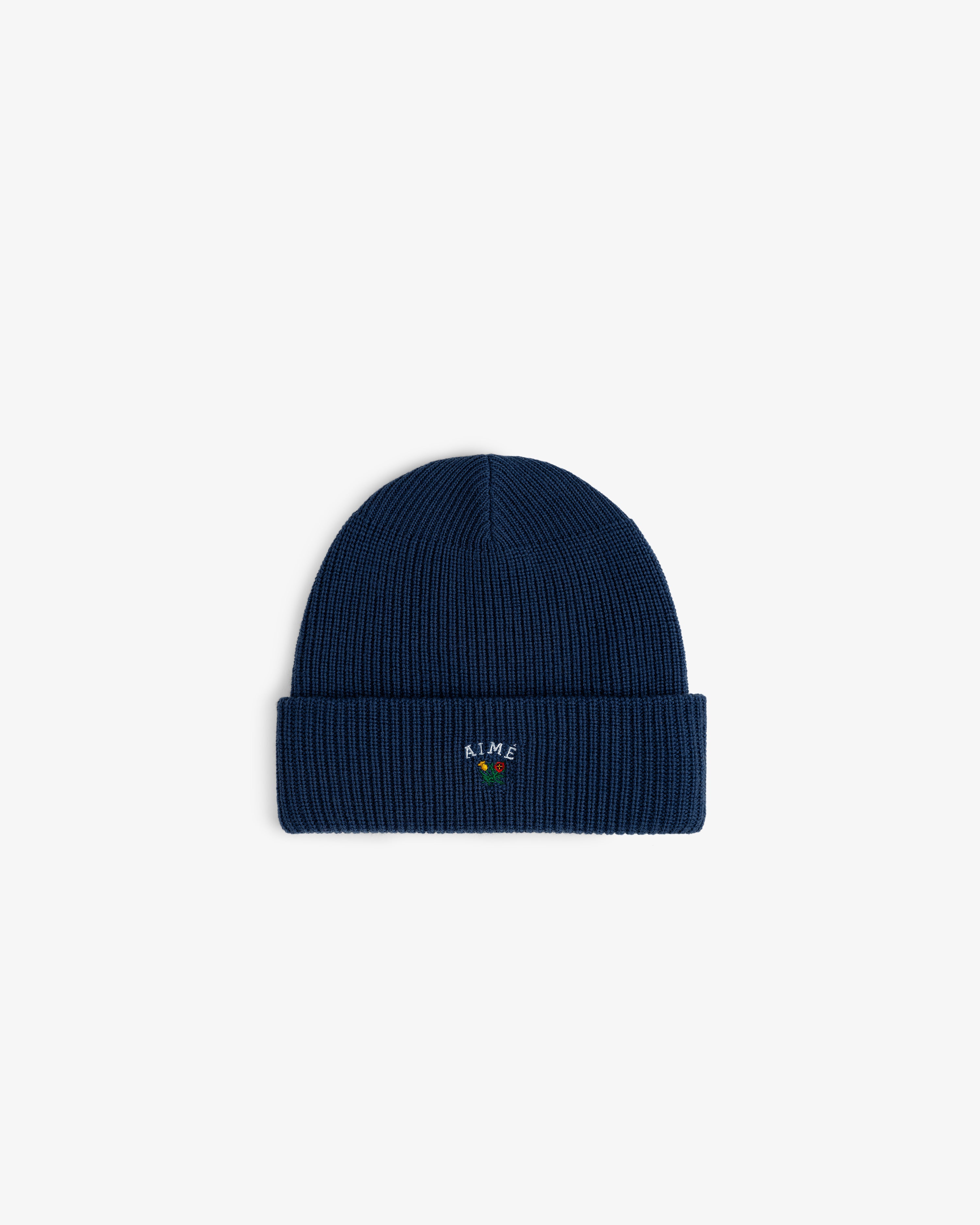 Crest Merino Wool Beanie: navy blue ribbed knit with folded cuff and small colorful embroidered front text.