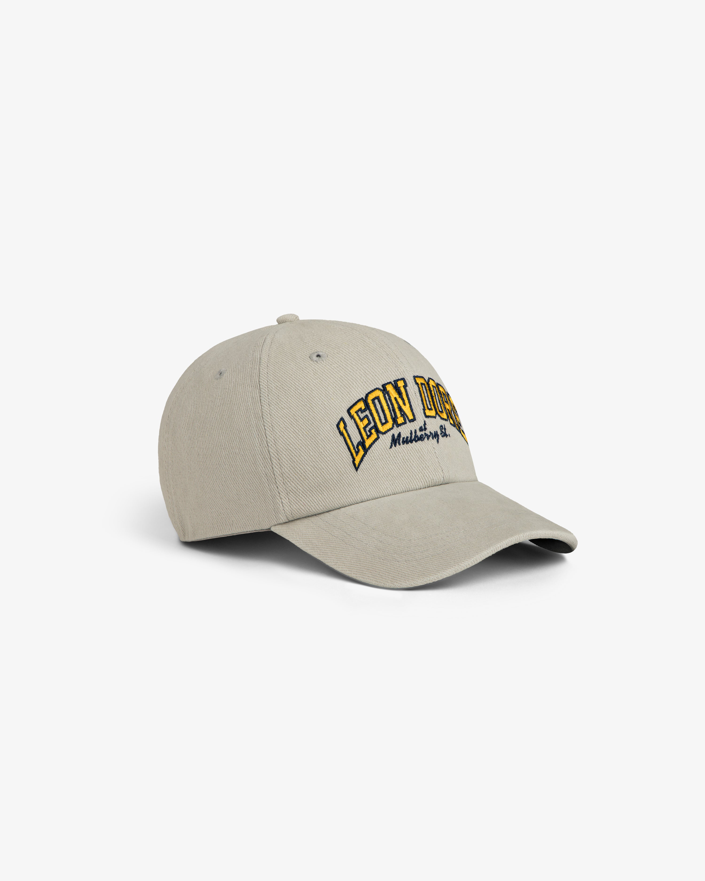 Mulberry Letterman Hat in beige with LEON DORE and small yellow & black text embroidered on the front.