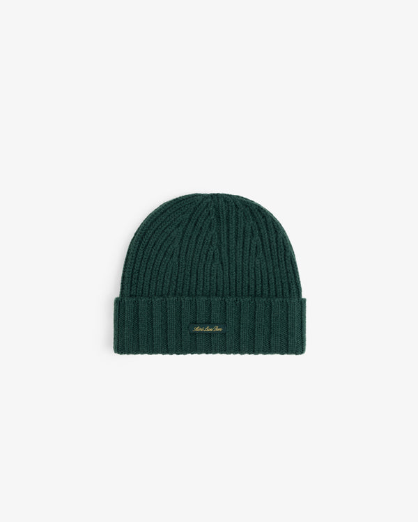 Dark green ribbed Cashmere Beanie with a folded cuff and a small gold logo tag.