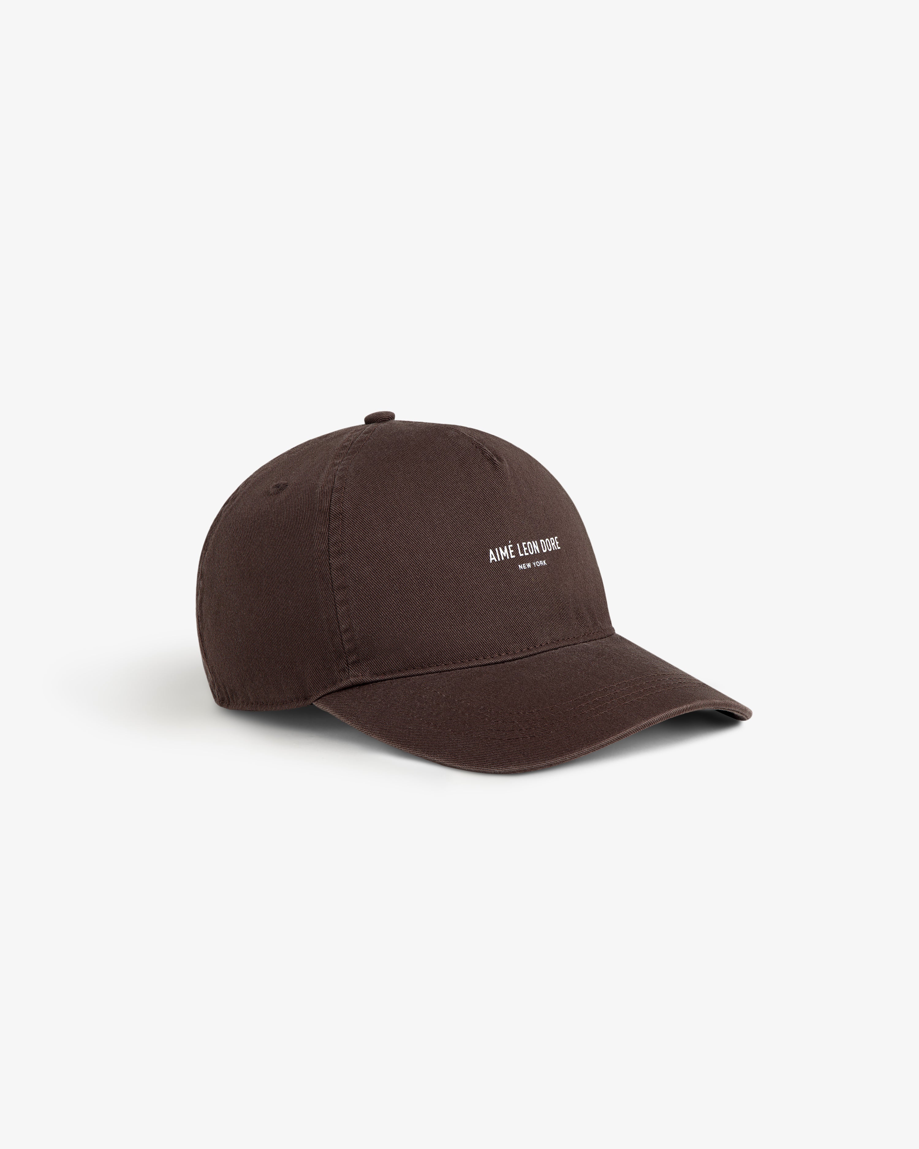 A brown Micro Logo Hat with AIMÉ LEON DORE text in white on front, displayed against a white background.