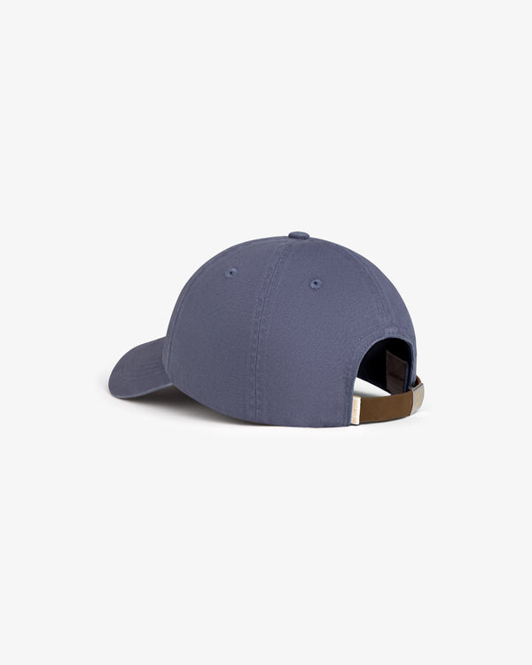 Crest Logo Hat in blue, shown from the back with adjustable brown strap and metal buckle on white background.