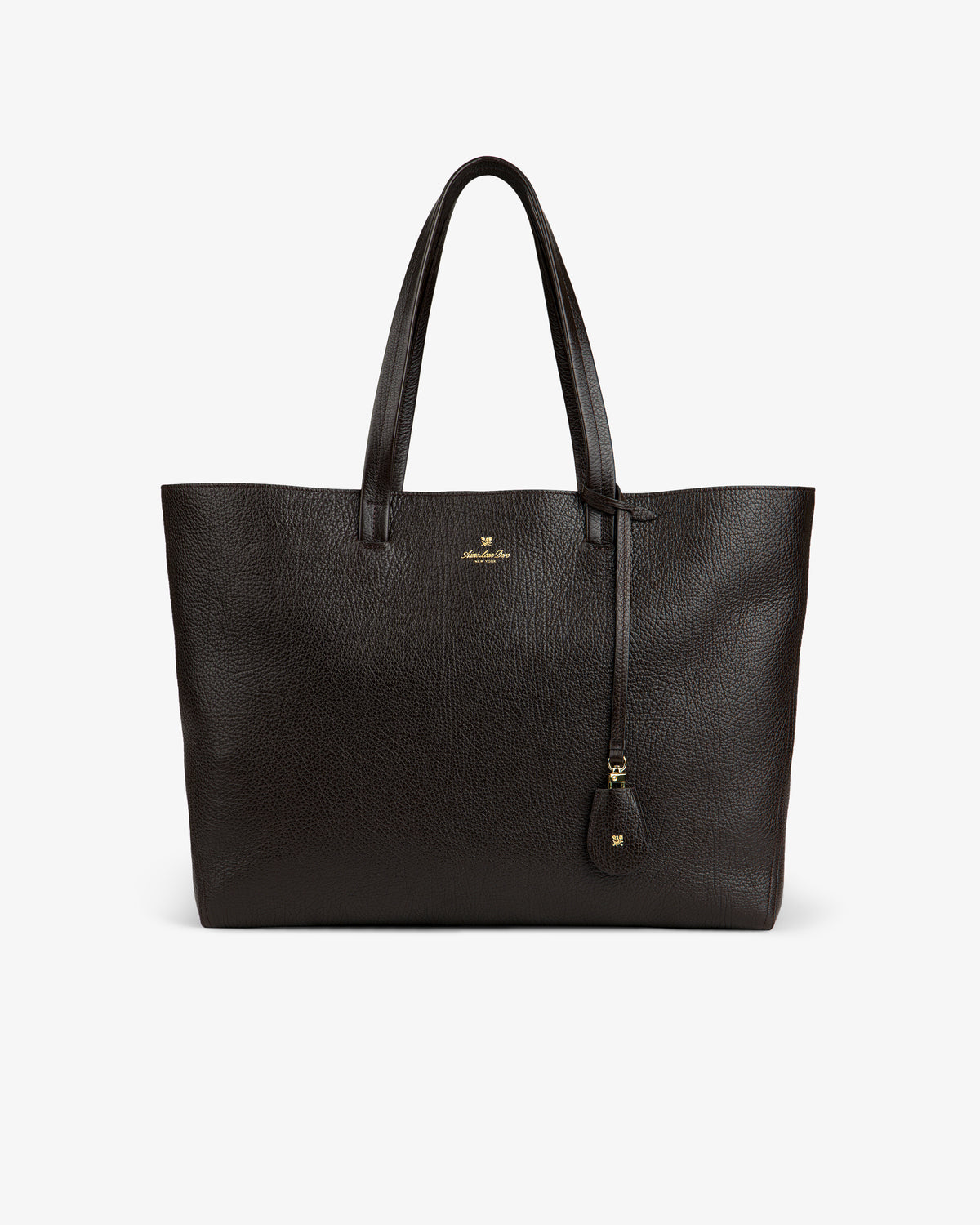 Tumbled Leather Tote Bag in dark brown with two handles, gold logo, and leather tag on a white background.