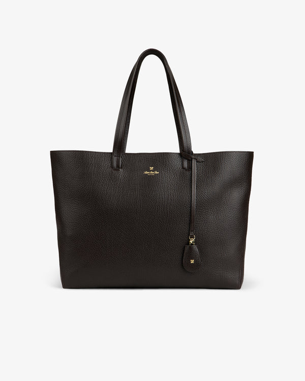 Tumbled Leather Tote Bag in dark brown with two handles, gold logo, and leather tag on a white background.