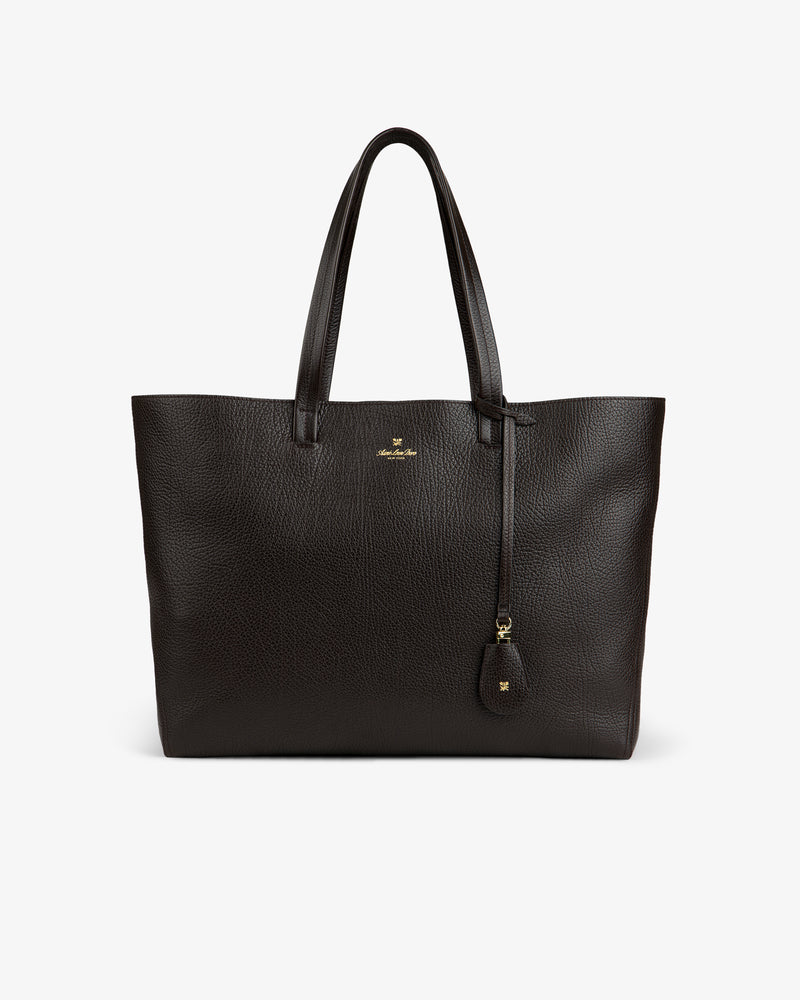Tumbled Leather Tote Bag in dark brown with two handles, gold logo, and leather tag on a white background.