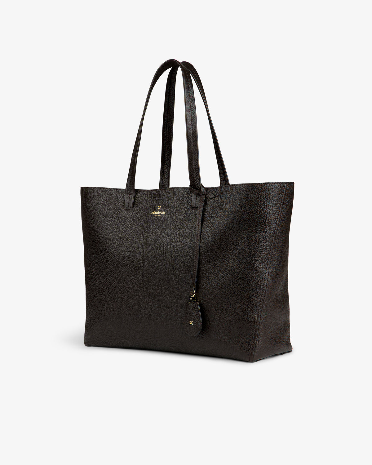 Tumbled Leather Tote Bag in dark brown with double handles, gold logo, and keychain on white background.