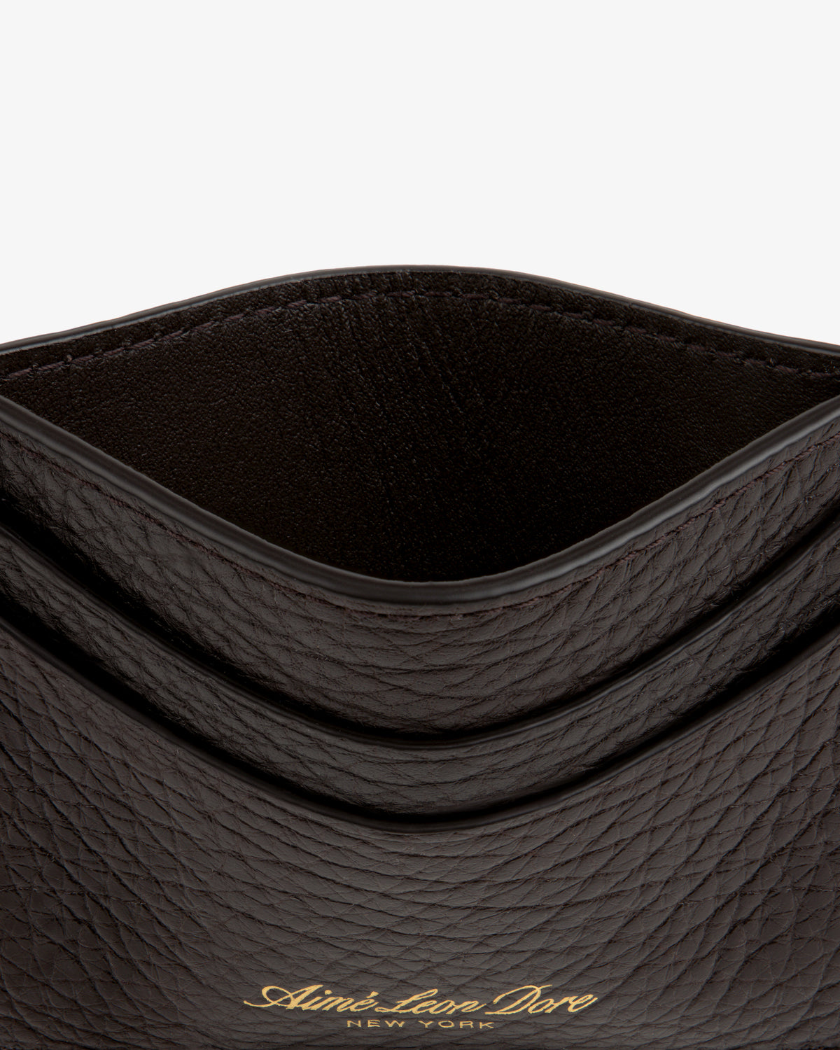 Close-up of an open Tumbled Leather Card Holder in textured dark brown with gold Aimé Leon Dore New York text on front.