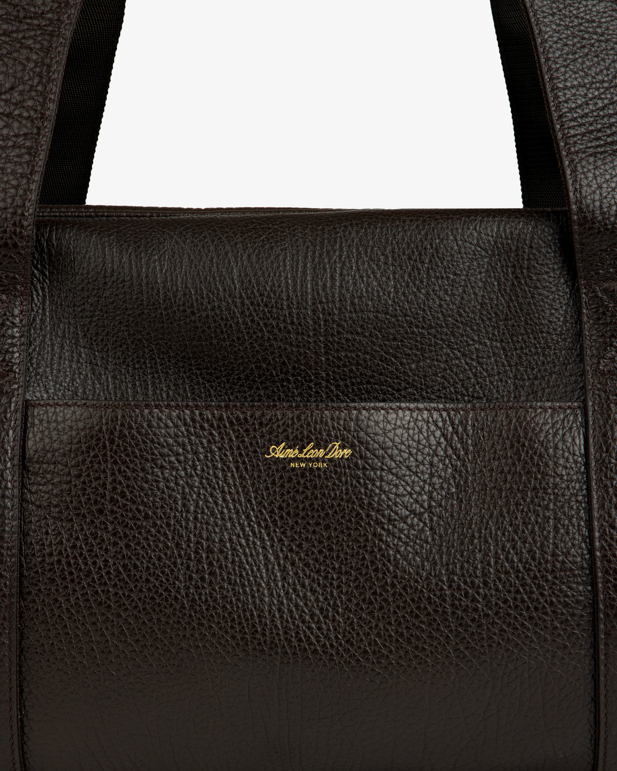Close-up of the Tumbled Leather Duffle in dark brown with gold Aimé Leon Dore NEW YORK logo on the front.