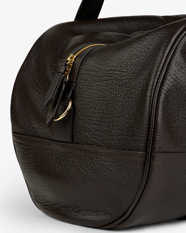 Close-up of the Tumbled Leather Duffle in textured dark brown leather with zip and gold hardware.