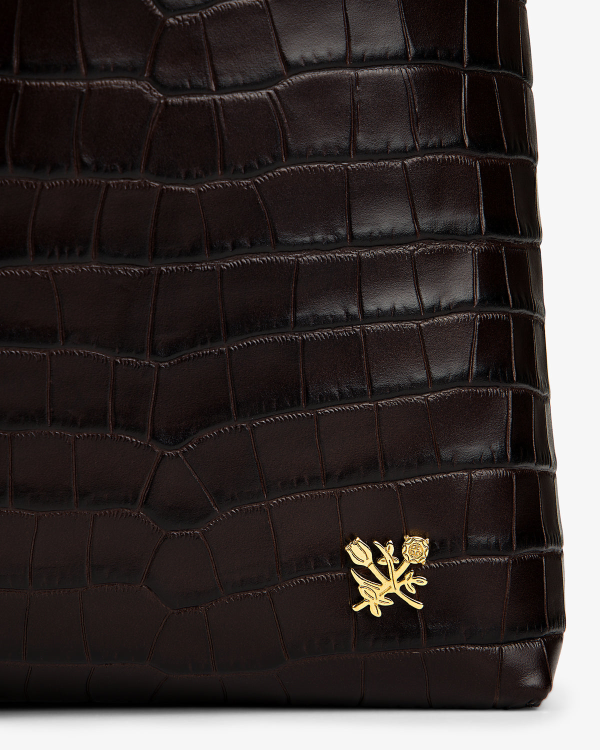 Croc-Embossed Leather Shoulder Bag in dark brown with a crocodile-embossed texture and a gold flower emblem.