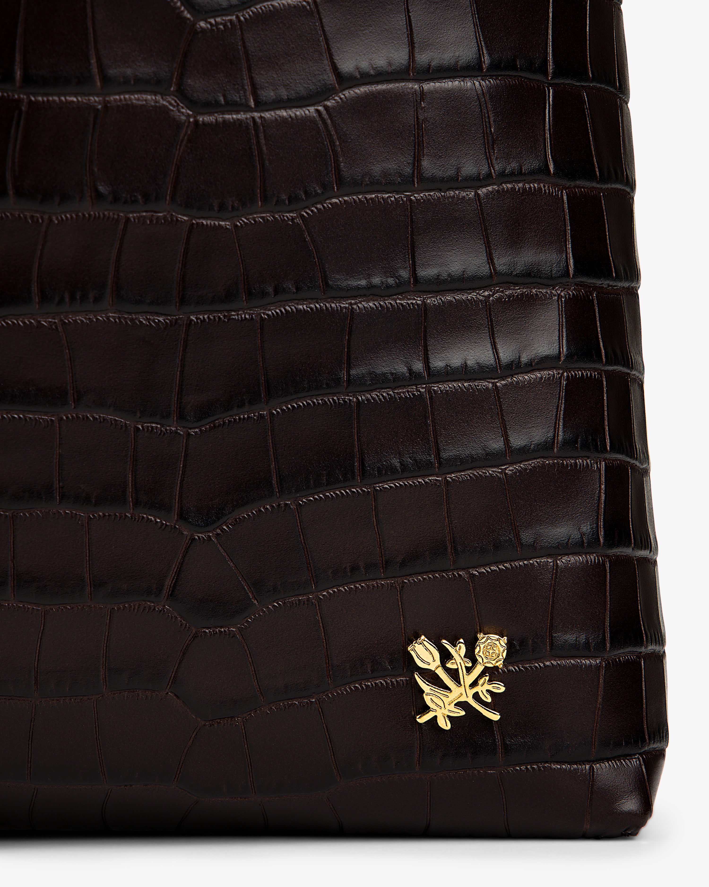 Croc-Embossed Leather Shoulder Bag in dark brown with a crocodile-embossed texture and a gold flower emblem.