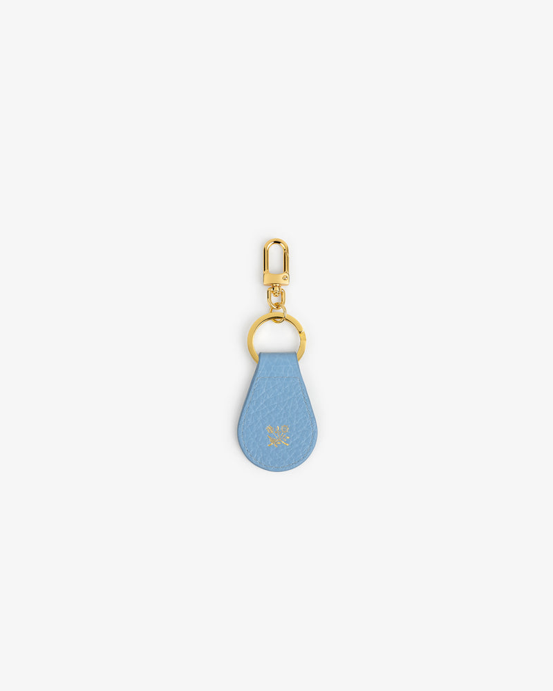 Tumbled Leather Key Fob: blue leather teardrop, gold hardware, small embossed logo near center.