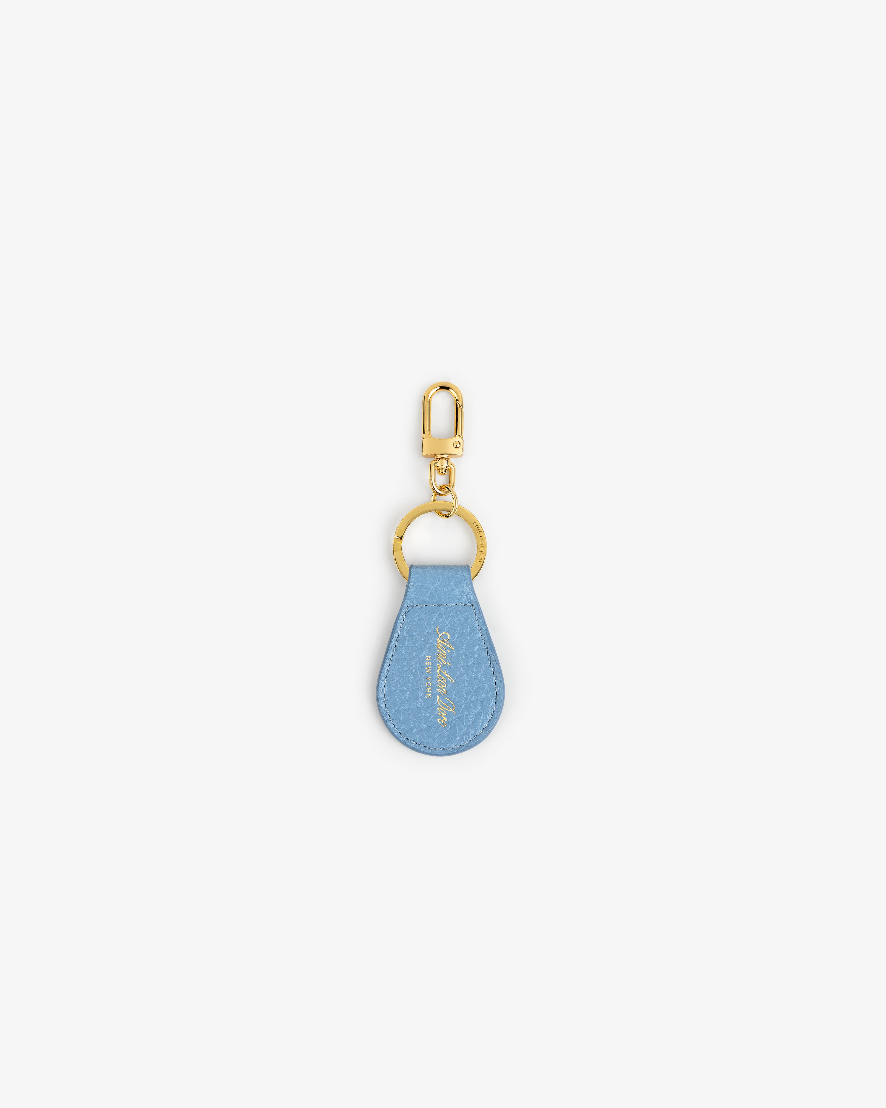 Tumbled Leather Key Fob: light blue teardrop design with gold hardware, shown on a white background.