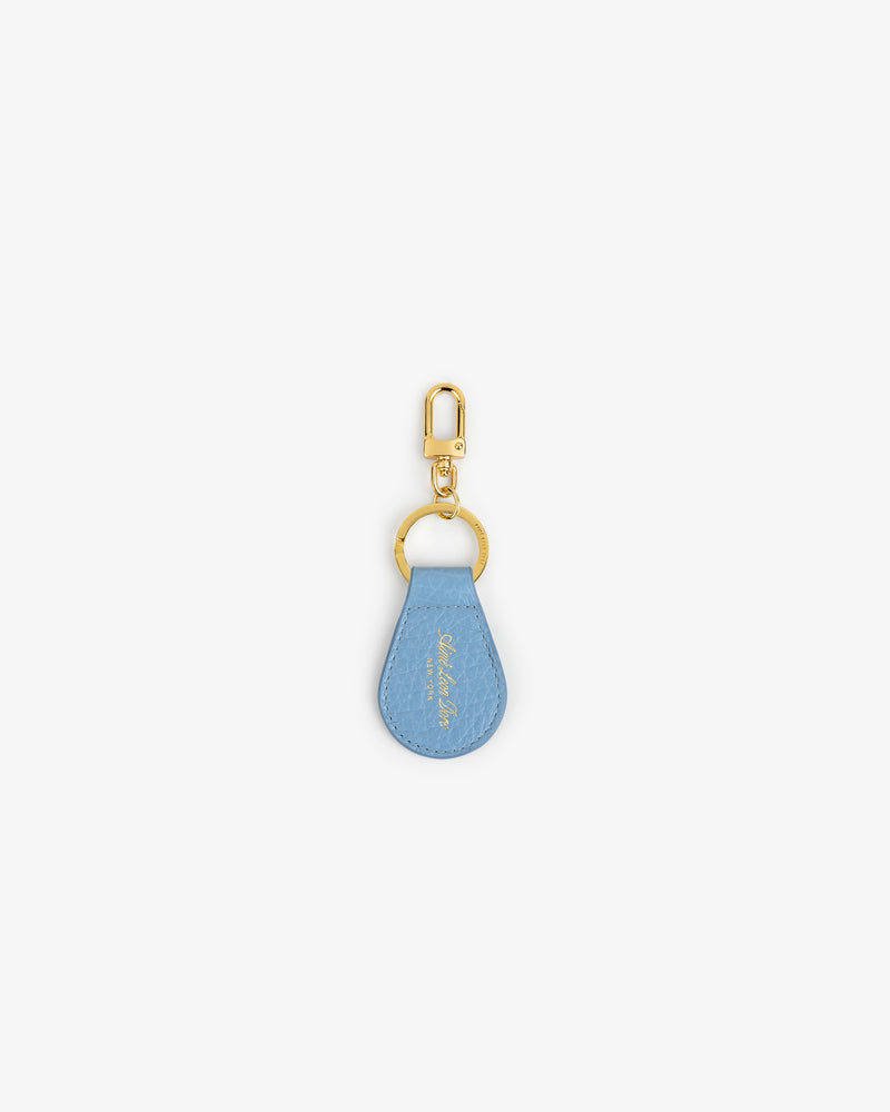 Tumbled Leather Key Fob: light blue teardrop design with gold hardware, shown on a white background.