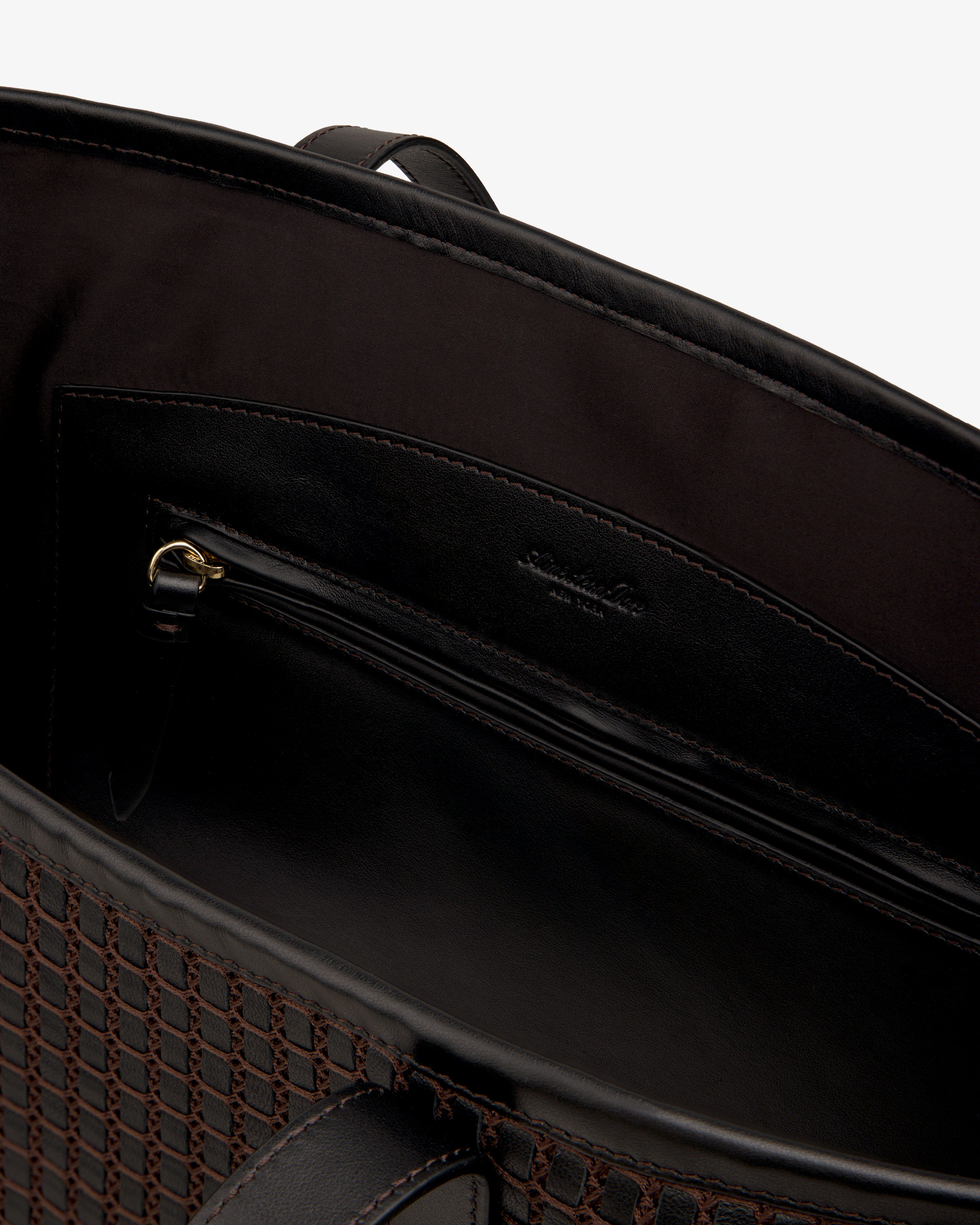 Interior view of a dark brown Woven Leather Tote Bag featuring a zippered pocket.