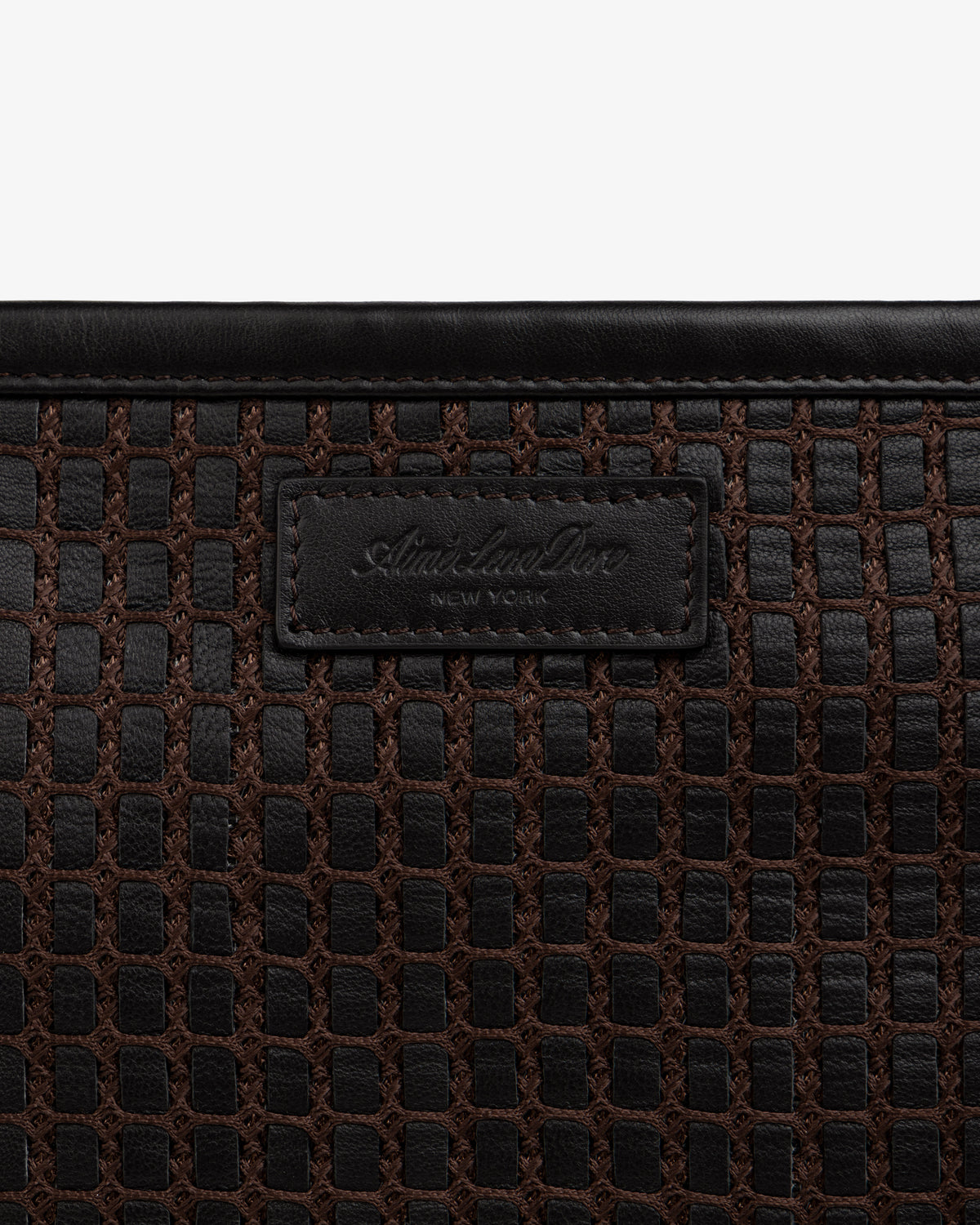 Close-up of a brown Woven Leather Tote Bag with a branded leather label.