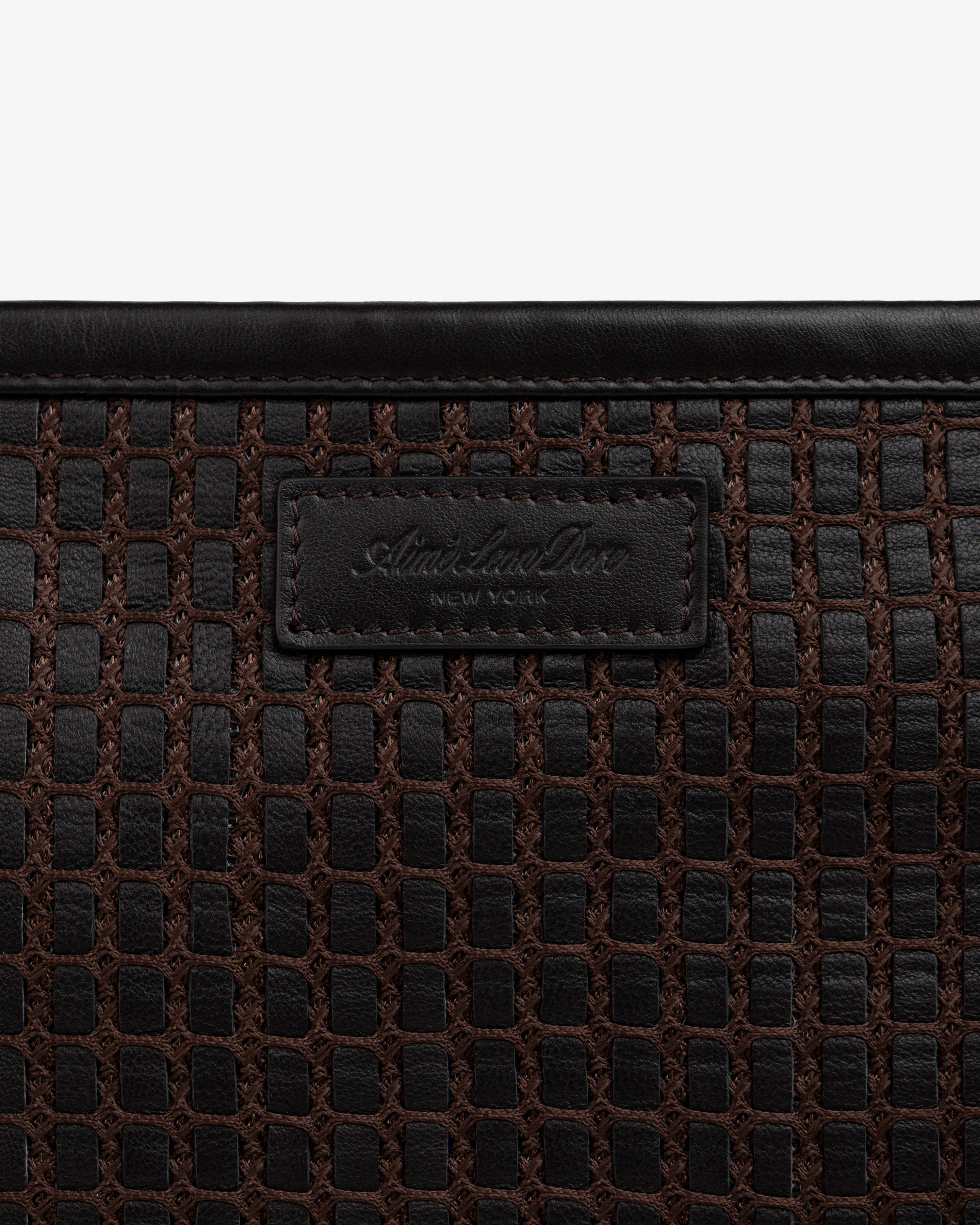 Close-up of a brown Woven Leather Tote Bag with a branded leather label.